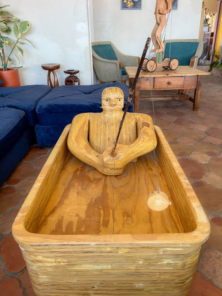 Wooden Man Fishing in a Bathtub by Hy Farber