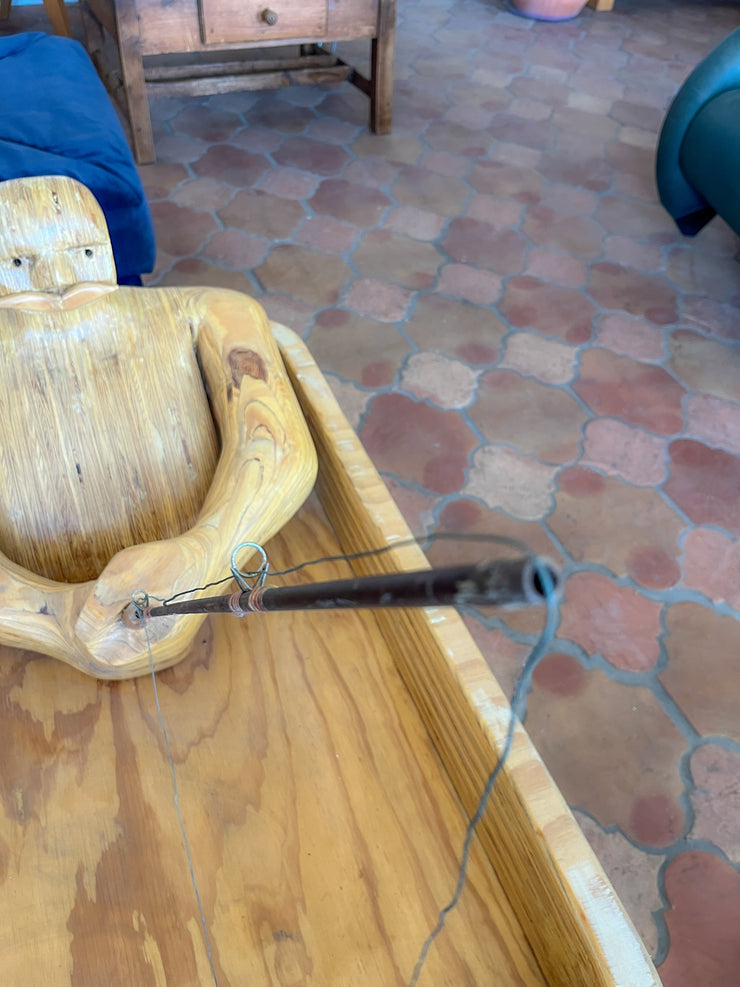 Wooden Man Fishing in a Bathtub by Hy Farber